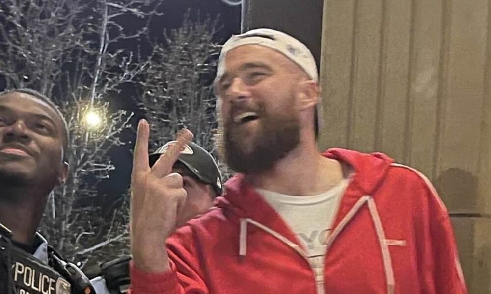 A THIRD red flag for Taylor! Fans slam 'tone deaf' Travis Kelce for posing for smiling selfie with KC cop in the wake of deadly shooting... after previously shoving his coach at Super Bowl and appearing too drunk to talk at parade