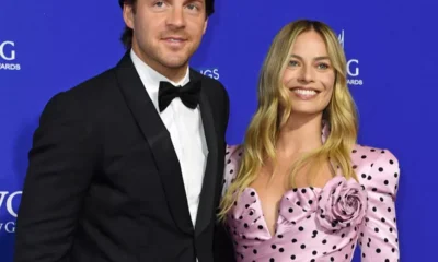 Margot Robbie pictured cradling her stomach amid pregnancy reports as she's expecting her first child with TomAckerley.